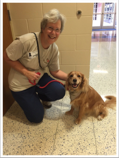 Barbara Ernst, Volunteer Therapy Worker, at work with Dinah, a Timshell Petite Golden Retriever